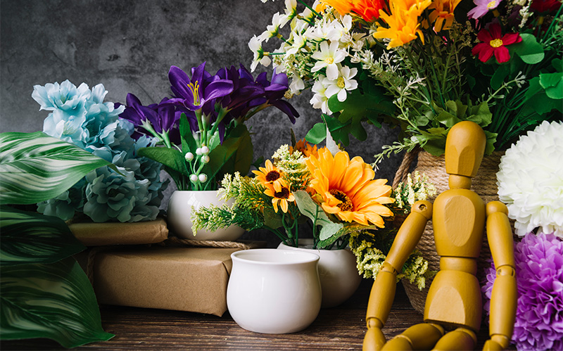 display-of-potted-flowers-vases-and-wooden-artist-mannequin